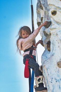 A young Girl Scout climbs a rock-climbing wall at the 2019 Outdoor Adventure Campout. Photo courtesy of Girl Scouts Heart of Central California